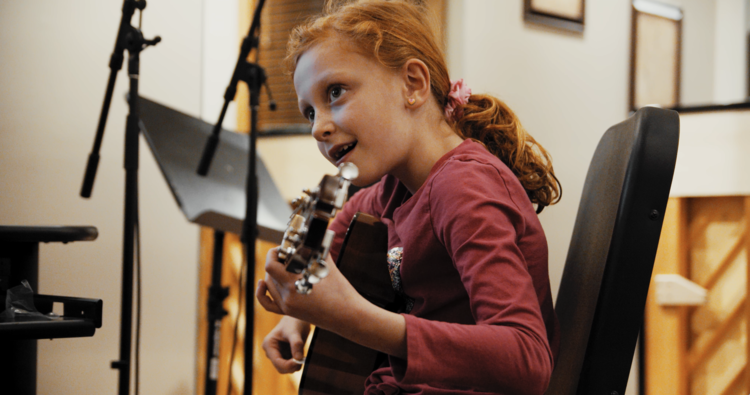 Young girl plays guitar