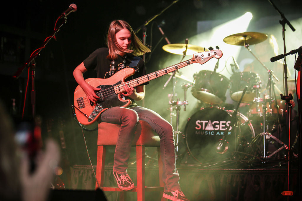 Student playing bass live on stage