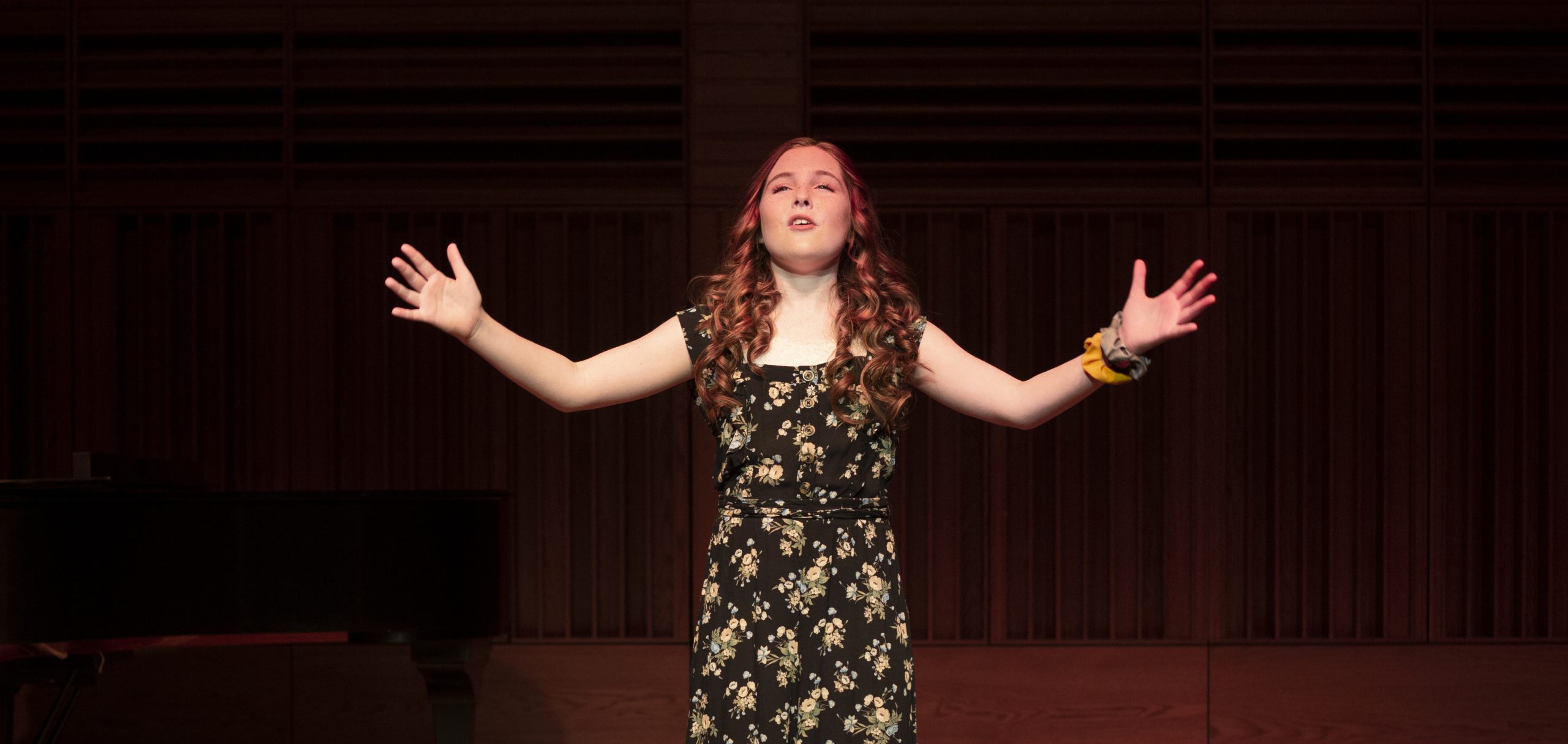 Girl singing with arms outstretched